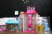Barbie Gift Shop playset with ATM, Barbie doll in lavender dress, Barbie Thumbelina gift set in sealed packaging, Barbie soap dispensers, and boxed Barbie Skipper Babysitters Inc.