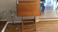 Full view of the wood drawing board with adjustable stand facing forward showing the tabletop surface and stand.