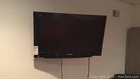 Front view of Panasonic television mounted on wall, showing screen and brand name.