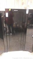 Full-front view of black Stack-On metal cabinet closed with door and lock shown