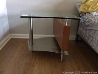 Front and side views of the glass top end table showing metal legs, wood panel and metal lower shelf.