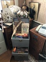 Overall view of lamp, shell shade, candlestick, prints and filing cabinet