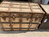 First vintage chest exterior showing metal bands, rivets, leather straps, and clasps.