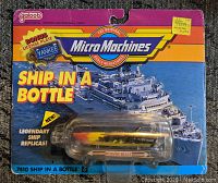 Front display of original sealed Micro Machines 'Ship in a Bottle' power boat toy packaging with colorful cardboard and clear plastic bottle showcasing the miniature boat inside.