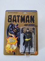 Full view of the packaged 1989 Batman action figure showing original gold packaging and accessories.