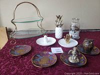 Photo of assorted glass and ceramic decor including a two-tiered glass dessert stand, various decorative dishes including owl dish, white ceramic pineapple container, two ring dishes with gold-tone hands, and owl ornament that opens.