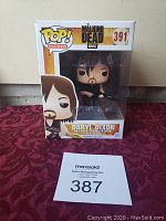 Funko Pop! figure of Daryl Dixon from The Walking Dead, number 391, in original box with MaxSold auction lot number in front