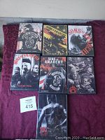 Seven DVD box sets for Sons of Anarchy seasons 1 through 7 laid out on a surface with an auction lot number visible.