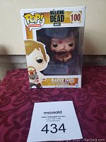 Front view of the boxed Funko Pop! figure of Injured Daryl from The Walking Dead, showing branding and figure inside.