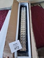 Photo of new LED light bar for Ram truck, showing the light bar in its original cardboard box with foam padding and MasSold lot number card.