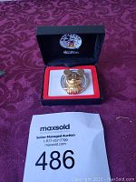 Mickey Mouse brooch in black and red velvet-lined box with Mickey Mouse logo on lid, accompanied by MaxSold auction card.