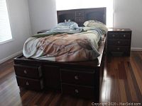 Full front view of queen storage bed showing headboard and base drawers