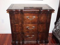 Front view of small dresser showing three drawers and brass-tone handles