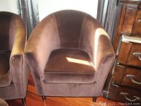 Front angled view showing velvet bucket chair with brown upholstery, curved design, and cushioned seat.