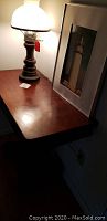 Close up of the lamp and table surface showing wood finish and lamp details