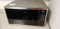 Full view of Samsung countertop microwave showing stainless steel body and digital control panel on right.
