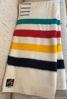 Full view of folded wool blanket showing stripes and Trapper Point label