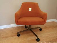 Front view of orange corduroy swivel chair on caster base