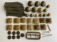 Top-down view showing entire collection of WWII Canadian brass uniform buttons, rank pips, olive wool tabs, brass buckle, and pins.