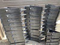 Stacked view of multiple black triangular plastic rink brackets