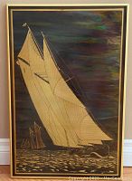 Front view of a framed brass etching artwork depicting the Bluenose sailing ship with a dark colored background highlighting gold etched lines.