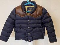 Front view of navy blue boys down jacket with brown leather yoke and snap button front closure on hanger.