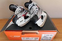 Pair of Nike Bauer Vapor Edge junior ice hockey skates on top of original box showing overall condition and design.