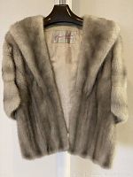 Front view of vintage fur stole showing the soft fur and shawl collar design on a hanger.