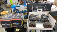 Hosim 4WD truck and two UniDargon RC cars in boxes along with a Taaiw 360 flip car box on shelving