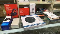 Photo showing Mpow BH415A wireless gaming headset, Mpow H21 wireless headphones, dual charging dock for PS4 controller, Mymahoi MP3 player, indoor digital HDTV antenna, and screen protector box.