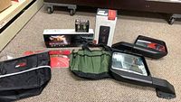 Photo showing all items in the lot including two side mirrors, black and green organizers, license plate frame, rear view mirror camera, and LED turn signal light.