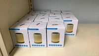 Nine boxed generic touch-sound lamp Bluetooth speakers on shelf
