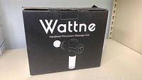 Black box packaging with Wattne brand and image of handheld percussion massage gun
