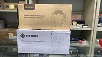 Boxes of MaxKare Shiatsu Shoulder Massager and Fit King Air Compression Therapy Device