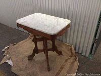 Full view of the antique carved wooden table with attached marble top showing the size and overall condition.