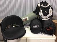 Lot overview with all items: foldable chair, green sleeping pad, two sleeping bags (one Coleman branded), and black and white backpack.