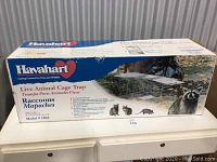 Box of Havahart live animal cage trap for raccoons, showing front and side details.