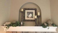 Full display of decor on mantel with polar bear art, candle holders, finials, and greenery.