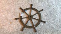 Top view of the bronze ship's wheel showing eight handles and overall condition