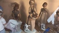 Group photo of three Lladro porcelain figures featuring young girls with pets.