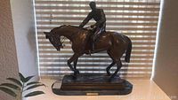 Full view of bronze racehorse and jockey sculpture on base