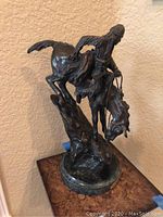 Full view of bronze-tone “Mountain Man” sculpture on marble base