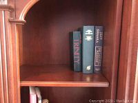 Photo of books including Trinity, The New Strong's Exhaustive Concordance of the Bible, and The Castle Treasury on a wooden shelf