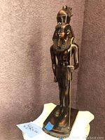 Full view of Egyptian bronze statue showing detailed headdress and staff