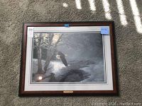 Framed print featuring a bald eagle flying over a river with trees in the background, showing overall artwork and frame.