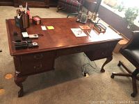 Desk overview showing top surface, pedestals, brass hardware and chair partially visible