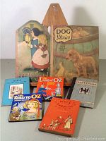 Seven vintage children's illustrated books displayed on table showing front covers and spines, with Hansel and Gretel shaped cover and Dog Stories prominently placed