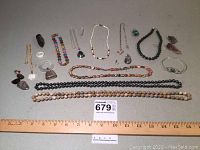 Overview of the entire jewelry collection showing necklaces, brooches, loose stones, and other pieces arranged together.