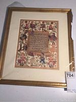 Full view of framed scherenschnitte artwork artwork with gold painted wood frame and light matting, showing slight damage to frame corner.