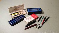 Overview of collection including boxed pen and pencil sets, assorted loose pens, mechanical pencils and loose nibs. Includes Sheaffer sets and Omiroid set.